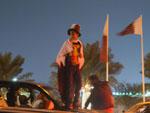 Man supporting Qatari colours standing on bonnet